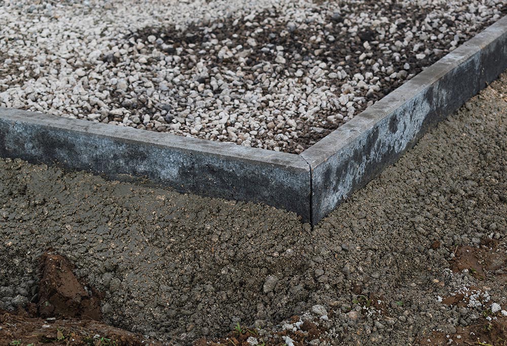 Professionelles Setzen von Kantsteinen zur stabilen Begrenzung von Pflasterflächen, Einfahrten und Gartenwegen durch AS Garten- & Bau.