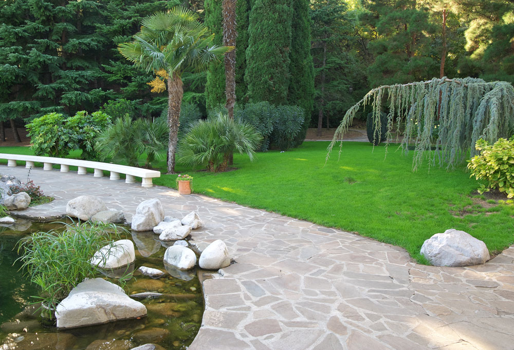 Modern gestaltete Terrasse aus Naturstein mit hochwertiger Pflasterung und stilvoller Optik – professionell umgesetzt von AS Garten- & Bau.